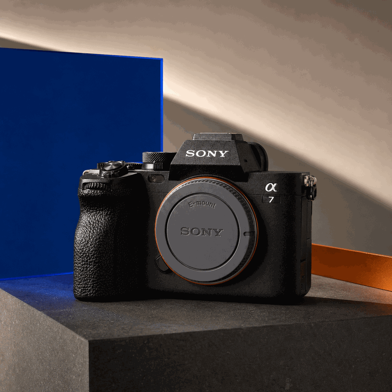 Sony Alpha 7 IV body with a grey E-mount body cap on a blue, orange and charcoal FRAMEHAUS studio set